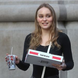 Lily Rose Depp se balade dans le quartier de Soho une pizza et un soda à emporter dans les main à New York, le 30 mai 2018