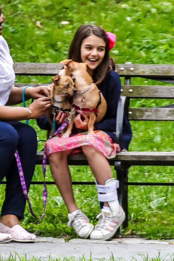 Suri Cruise, une attelle à la cheville, joue avec ses chiens dans un parc à New York, le 23 juin 2018.