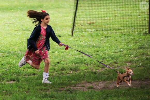 Suri Cruise, une attelle à la cheville, joue avec ses chiens dans un parc à New York, le 23 juin 2018.