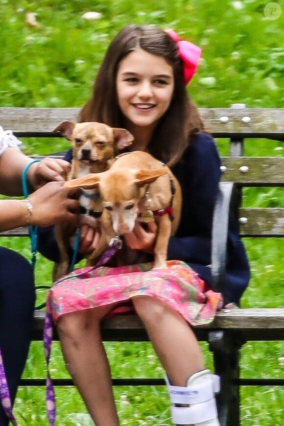 Suri Cruise, une attelle à la cheville, joue avec ses chiens dans un parc à New York, le 23 juin 2018.