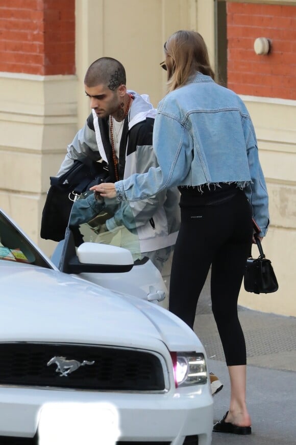Exclusif - No web - Gigi Hadid et son compagnon Zayn Malik à la sortie d'un immeuble à New York. Zayn s'est rasé les cheveux et laisse apparaitre un nouveau tatouage sur son crâne... Le 31 juillet 2018  For germany call for price Exclusive - Gigi Hadid and Zayn Malik load up a car as they head out from their apartment in New York together. Zayn shows off a new tattoo with a shaved head as he loads a duffle bag into a car with Gigi at his side in a crop top denim jacket and black leggings. 31st july 201831/07/2018 - New York