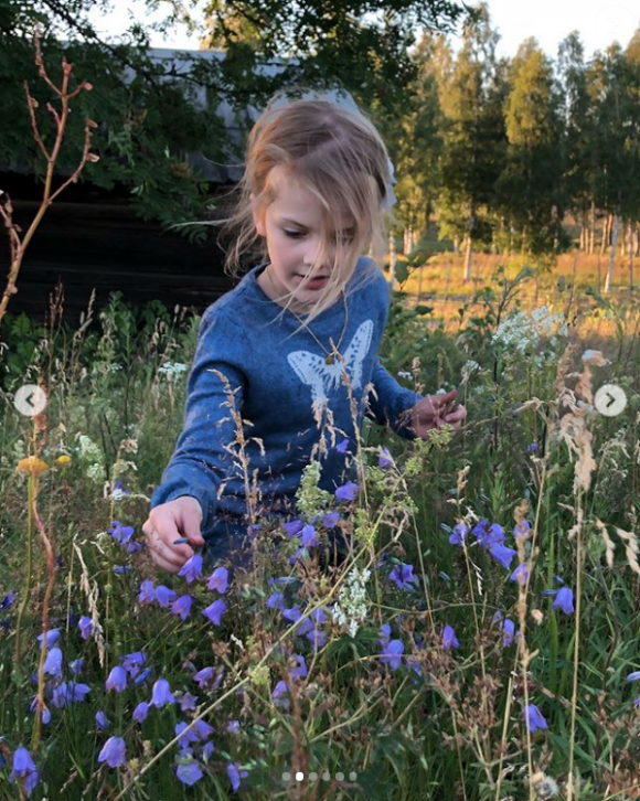 La princesse Estelle de Suède cueille des fleurs lors de ses vacances en famille au cours de l'été 2018, photo Instagram de la princesse héritière Victoria de Suède.