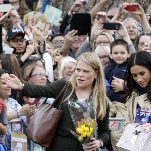 Le prince Harry, duc de Sussex, et Meghan Markle, enceinte, duchesse de Sussex, vont à la rencontre de la foule venue les accueillir, lors de la visite des jardins botaniques de Melbourne, le 18 octobre 2018.