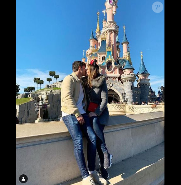 Dylan Deschamps avec sa compagne Mathilde échangent un baiser à Disneyland Paris. Février 2019.