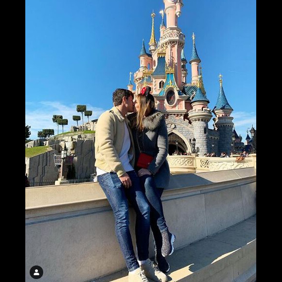 Dylan Deschamps avec sa compagne Mathilde échangent un baiser à Disneyland Paris. Février 2019.