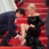 Niels Schneider rattachant la chaussure de Virginie Efira lors de la montée des marches du film Sibyl au Festival de Cannes le 24 mai 2019