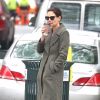 Katie Holmes porte un long manteau en laine kaki, des lunettes de soleil, une paire de Uggs marrons et un pantalon ample alors qu'elle regagne son domicile avec un café à emporter. New York, le 18 avril 2019.