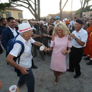 Semi-Exclusif - Brigitte Macron danse avec un vacancier - Le Président de la République Emmanuel Macron et sa femme la Première Dame Brigitte Macron (Trogneux) ont participé à un pot de l'amitié suivi d'un bain de foule sur la place centrale du village de Bormes-les-Mimosas, le 17 août 2018. © Luc Boutria / Nice Matin / Bestimage