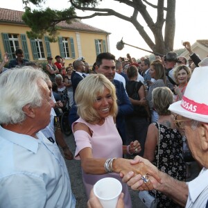 Semi-Exclusif - Brigitte Macron danse avec un vacancier - Le Président de la République Emmanuel Macron et sa femme la Première Dame Brigitte Macron (Trogneux) ont participé à un pot de l'amitié suivi d'un bain de foule sur la place centrale du village de Bormes-les-Mimosas, le 17 août 2018. © Luc Boutria / Nice Matin / Bestimage