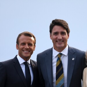 Le président français Emmanuel Macron, sa femme la Première Dame Brigitte Macron avec le Premier ministre canadien Justin Trudeau lors de l'accueil informel au sommet du G7 à Biarritz, France, le 24 août 2019.