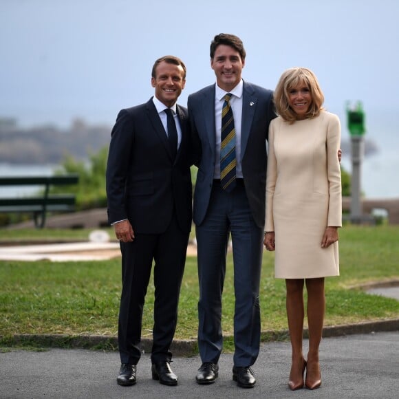 Le président français Emmanuel Macron, sa femme la Première Dame Brigitte Macron avec le Premier ministre canadien Justin Trudeau lors de l'accueil informel au sommet du G7 à Biarritz, France, le 24 août 2019.