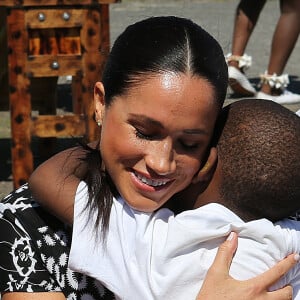 Meghan Markle, duchesse de Sussex, étreint un enfant dans le township de Nyanga, au Cap Afrique du Sud le 23 septembre 2019.