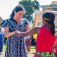 Meghan Markle, en robe Mayamiko, et le prince Harry, duc de Sussex, en visite dans le township de Nyanga, Afrique du Sud. Le 23 septembre 2019.