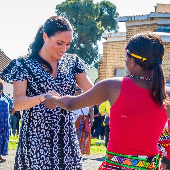 Meghan Markle, en robe Mayamiko, et le prince Harry, duc de Sussex, en visite dans le township de Nyanga, Afrique du Sud. Le 23 septembre 2019.