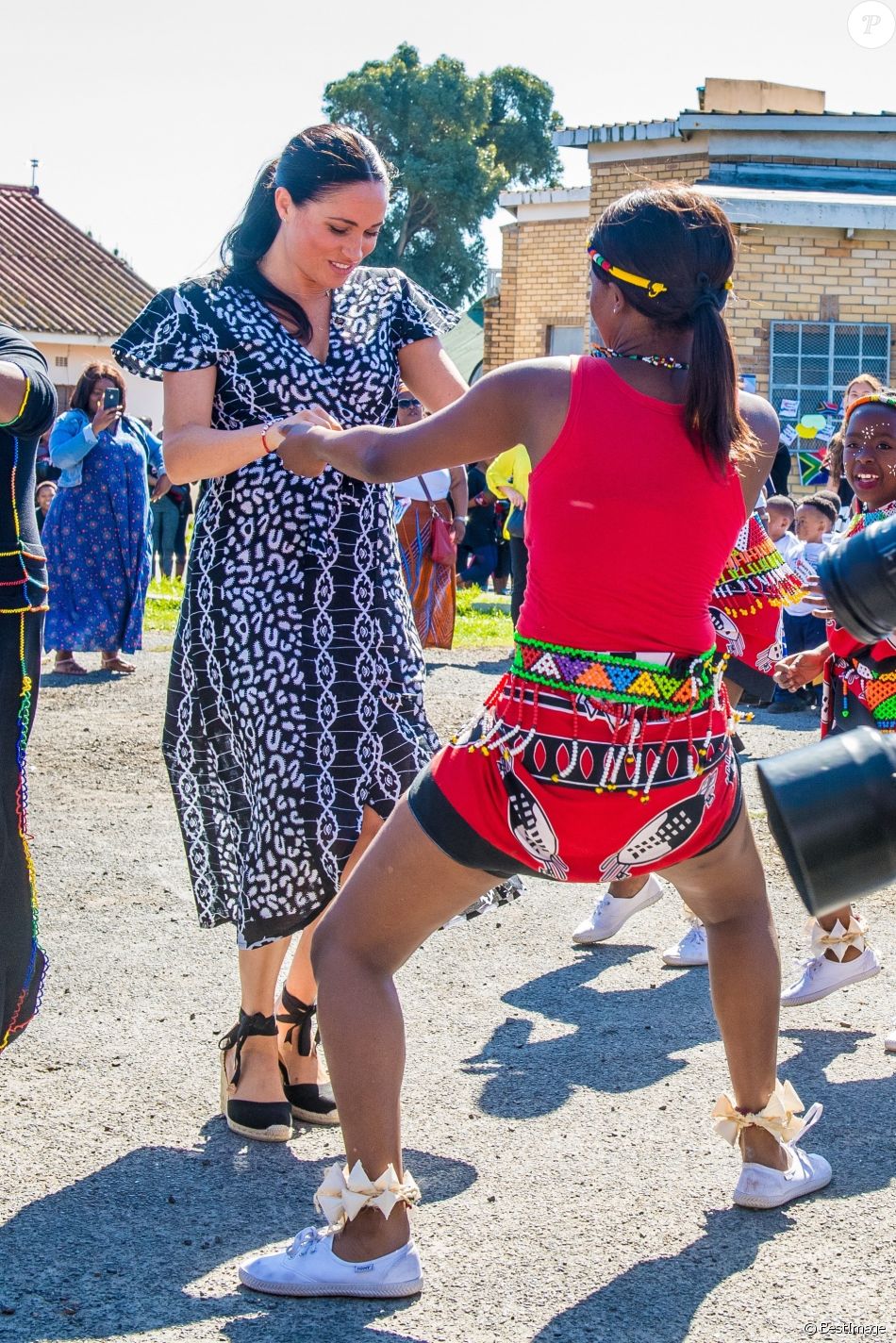 Meghan Markle, en robe Mayamiko, et le prince Harry, duc de Sussex, en visite dans le township de Nyanga, Afrique du Sud. Le 23 septembre 2019.