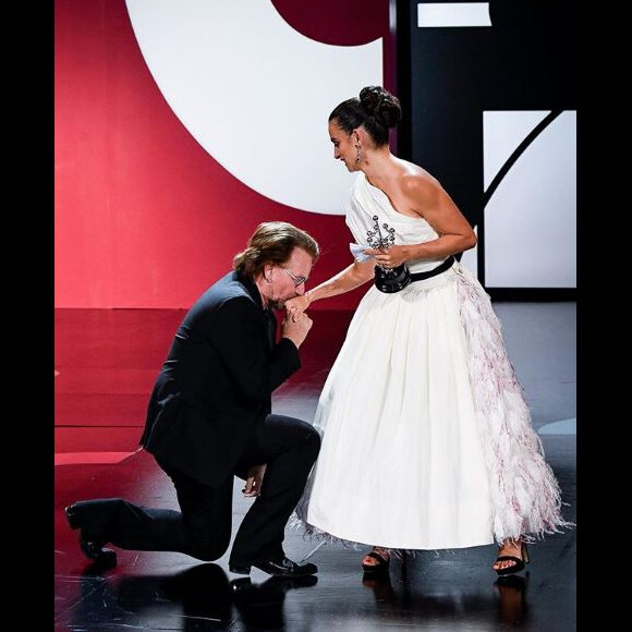 Bono s'agenouille face à Penélope Cruz au festival du film de Saint Sébastien le 27 septembre 2019.