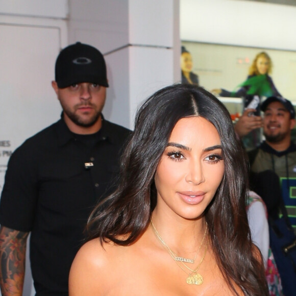 Kim Kardashian porte une robe longue moulante en satin à la sortie du magasin Ulta Beauty à New York, le 24 octobre 2019.