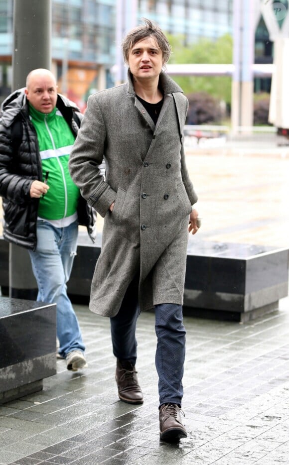 Le rocker Pete Doherty arrive aux studios de la BBC, il porte un long manteau ulster en laine gris et pose avec les fans à l'entrée. Salford, le 9 mai 2019.