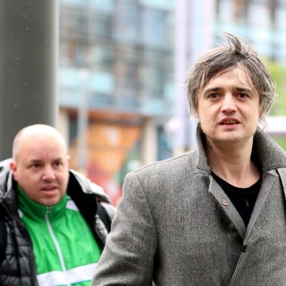 Le rocker Pete Doherty arrive aux studios de la BBC, il porte un long manteau ulster en laine gris et pose avec les fans à l'entrée. Salford, le 9 mai 2019.
