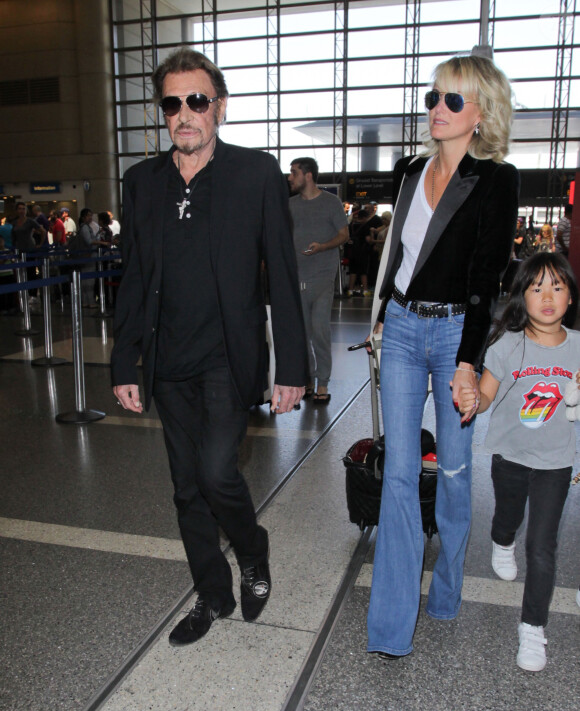 Johnny Hallyday avec sa femme Laeticia et ses enfants Jade et Joy en partance pour Paris arrivent à l'aéroport Lax de Los Angeles le 25 juin 2016.