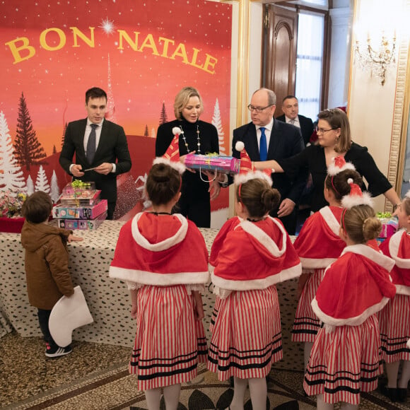 Distribution de cadeaux de Noël au palais princier de Monaco avec le prince Albert, la princesse Charlene, Louis Ducruet et Camille Gottlieb, le 18 décembre 2019.