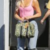 Khloe Kardashian porte un corset XXS rose, un jean déchiré et un sac camouflage Louis Vuitton à la sortie d'un studio dans le quartier de Calabasas à Los Angeles, le 3 septembre 2019.