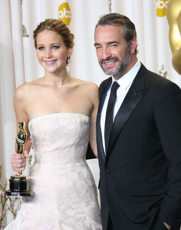 Jennifer Lawrence (robe Dior Haute Couture), Jean Dujardin - Photocall des laureats - 85eme ceremonie des Oscars a Hollywood le 24 fevrier 2013.