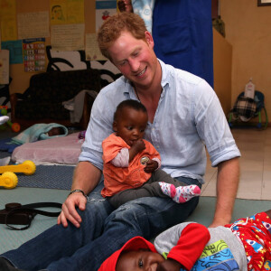 Le prince Harry d'Angleterre est assis avec des enfants pendant sa visite au club pour enfants ayant le sida "Mamohato Network Club" au St Paul Centre à Maseru, au Lesotho, le 9 décembre 2014.