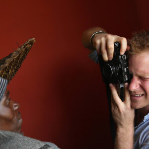 Le prince Harry d'Angleterre prend une photo avec un appareil Fuji X100s pendant sa visite d'une école construite par Sentebale lors de sa visite au Lesotho à Mokhotlong, le 8 décembre 2014.