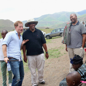 Le prince Harry d'Angleterre danse avec des jeunes et le prince Seeiso du Lesotho (chapeau) pendant la visite d'une école construite par Sentebale à Maseru, le 8 décembre 2014.