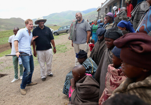 Le prince Harry d'Angleterre danse avec des jeunes et le prince Seeiso du Lesotho (chapeau) pendant la visite d'une école construite par Sentebale à Maseru, le 8 décembre 2014.