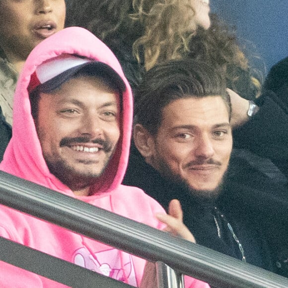 Kev Adams et Rayane Bensetti dans les tribunes lors du match de championnat de Ligue 1 Conforama opposant le Paris Saint-Germain (PSG) aux Girondins de Bordeaux au Parc des Princes à Paris, France, le 23 février 2020. Le PSG a gagné 4-3. © Cyril Moreau/Bestimage