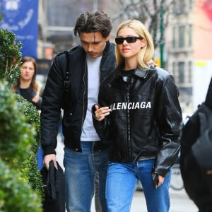 Brooklyn Beckham et sa petite amie Nicola Peltz, tous deux habillés de vestes noires et de jeans bleus, se baladent main dans la main à New York. Le 11 mars 2020.