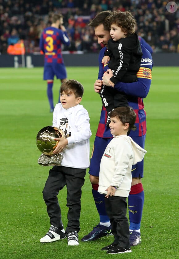 Lionel Messi pose avec son sixième Ballon d'Or et ses fils Thiago, Mateo et Ciro, avant le match de La Liga qui oppose Barcelone à Majorque, au Stade Camp Nou à Barcelone, le 7 décembre 2019.
