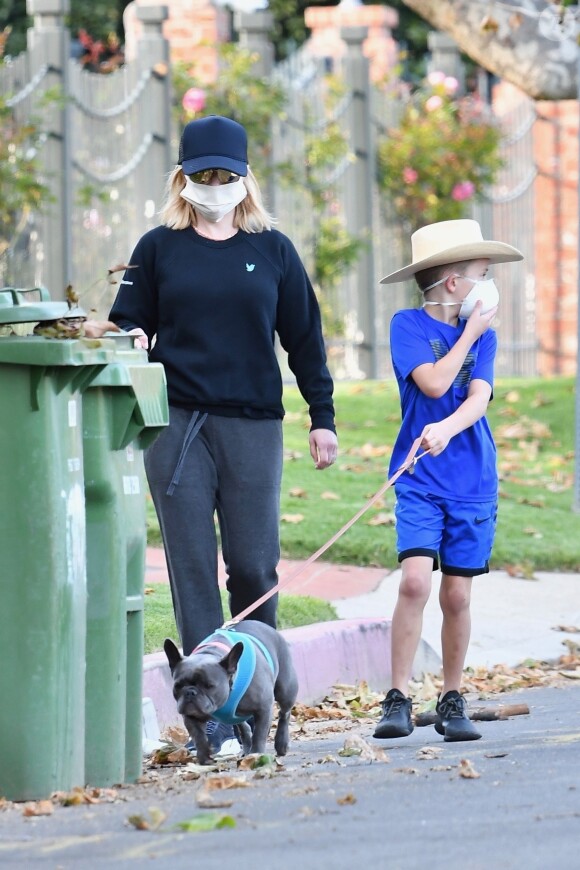 Exclusif - Reese Witherspoon et son fils Tennessee James, tous deux équipés de masques de protection, promènent leurs chiens près de leur maison à Los Angeles, pendant le confinement dû au coronavirus (Covid-19), le 13 avril 2020.