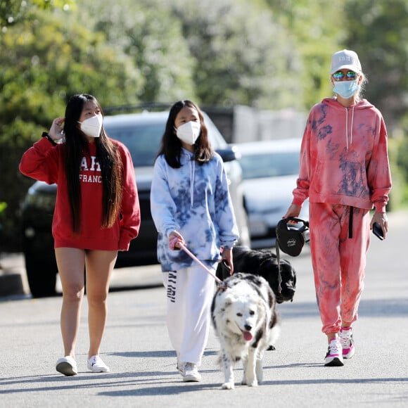 Laeticia Hallyday, ses filles Jade et Joy, Christina, avec des masques, et leurs chiens Santos, Cheyenne et Bono se promènent dans le quartier de Pacific Palisades, à Los Angeles, Californie, Etats-Unis, le 3 avril 2020, pendant la période de confinement.