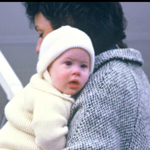 Le prince Harry dans les bras de sa nourrice à Aberdeen, en 1985.