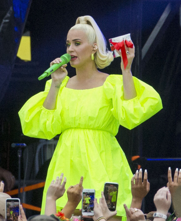 Katy Perry enceinte et en concert caritatif à Melbourne, en Australie, vêtue d'une robe jaune fluo Valentino. Le 11 mars 2020.