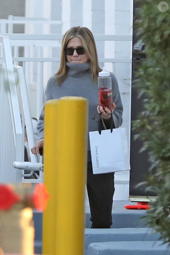 Exclusif - Jennifer Aniston quitte l'institut de beauté "Shani Darden" à Beverly Hills, avec une bouteille d'eau fruitée à la main, le 15 janvier 2020.