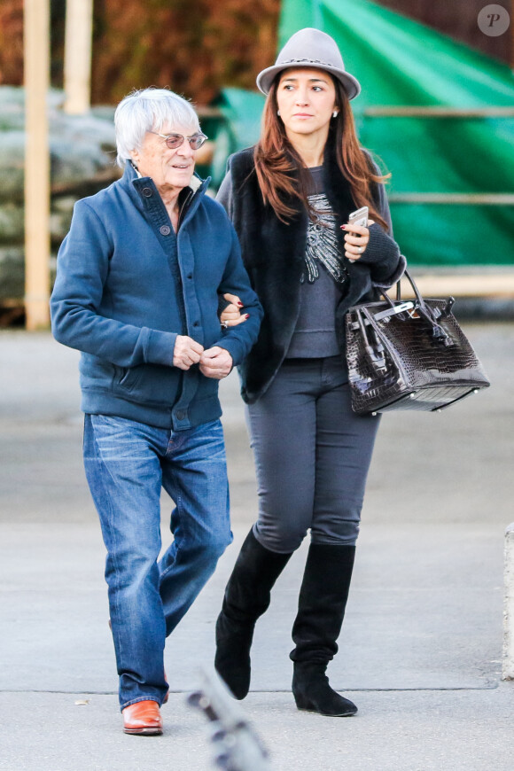 Exclusif - Bernie Ecclestone se promène avec sa femme Fabiana Flosi et des amis dans les rues de Gstaad pendant leurs vacances. Le 22 décembre 2014.