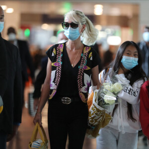 Laeticia Hallyday et ses filles Jade et Joy arrivent, avec des masques de protection contre l'épidémie de coronavirus (Covid-19), à l'aéroport de Paris-Charles-de-Gaulle à Roissy-en-France, France, le 18 juin 2020.