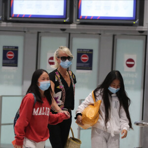 Laeticia Hallyday et ses filles Jade et Joy arrivent, avec des masques de protection contre l'épidémie de coronavirus (Covid-19), à l'aéroport de Paris-Charles-de-Gaulle à Roissy-en-France, France, le 18 juin 2020.