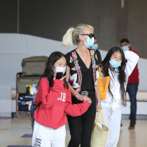 Laeticia Hallyday et ses filles Jade et Joy arrivent, avec des masques de protection contre l'épidémie de coronavirus (Covid-19), à l'aéroport de Paris-Charles-de-Gaulle à Roissy-en-France, France, le 18 juin 2020.