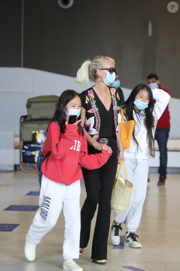 Laeticia Hallyday et ses filles Jade et Joy arrivent, avec des masques de protection contre l'épidémie de coronavirus (Covid-19), à l'aéroport de Paris-Charles-de-Gaulle à Roissy-en-France, France, le 18 juin 2020.