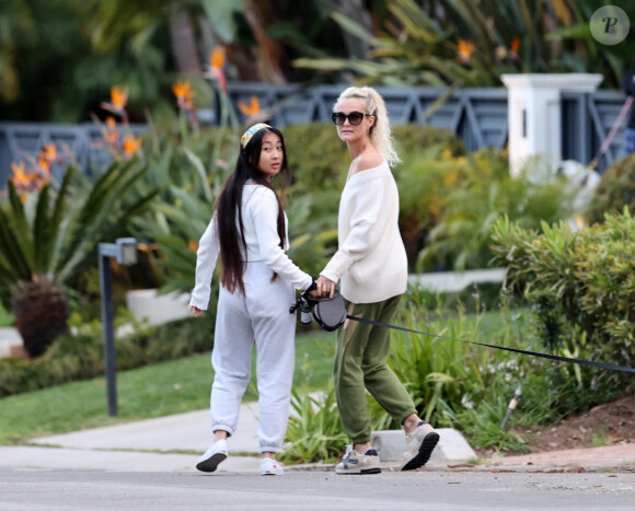 Laeticia Hallyday et ses filles Jade, 15 ans, et Joy, 11 ans, promènent leur chien Cheyenne dans le quartier de Brentwood à Los Angeles, pendant la période de confinement liée à l'épidémie de coronavirus (Covid-19), le 1er avril 2020.