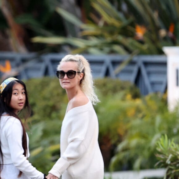 Laeticia Hallyday et ses filles Jade, 15 ans, et Joy, 11 ans, promènent leur chien Cheyenne dans le quartier de Brentwood à Los Angeles, pendant la période de confinement liée à l'épidémie de coronavirus (Covid-19), le 1er avril 2020.