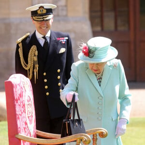 La reine Elisabeth II d'Angleterre remet au capitaine Thomas Moore son titre de chevalier lors d'une cérémonie au château de Windsor, le 17 juillet 2020.