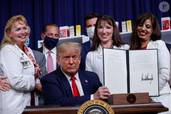 Le président des États-Unis, Donald Trump montre un décret sur la réduction des prix des médicaments lors d'une cérémonie à Washington le 24 juillet 2020.