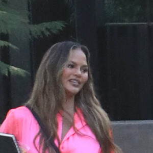 Exclusif - Chrissy Teigen porte une robe chemise en satin rose en balade à Pumpkin Farm à Los Angeles pendant l'épidémie de coronavirus (Covid-19), le 25 octobre 2020.