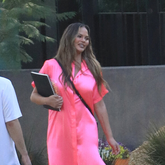 Exclusif - Chrissy Teigen porte une robe chemise en satin rose en balade à Pumpkin Farm à Los Angeles pendant l'épidémie de coronavirus (Covid-19), le 25 octobre 2020.